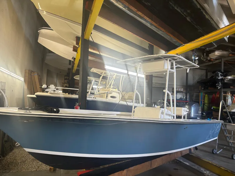 Slide: The Image of 1971 SeaCraft Barcone 21 CC boat in storage, blue hull, indoor facility. - 3