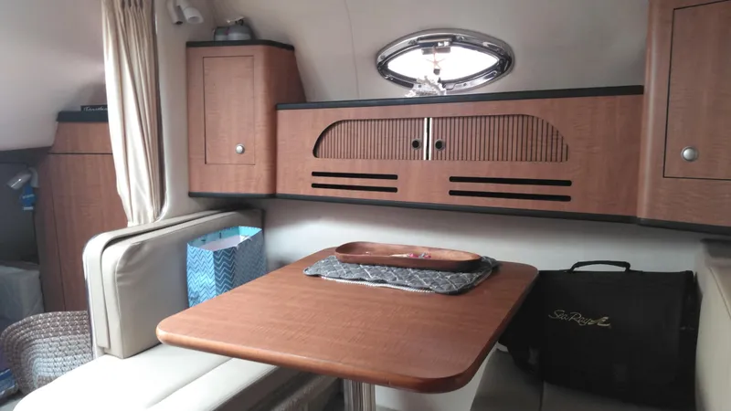 Slide: The Image of Interior of 2006 Sea Ray 280 Sundancer with wooden table and storage cabinets. - 10