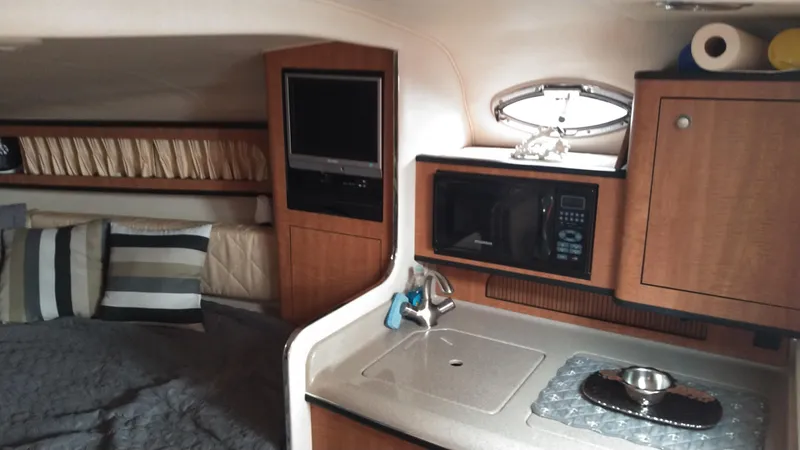 Slide: The Image of Interior of 2006 Sea Ray 280 Sundancer with kitchenette, bed, and TV. - 11