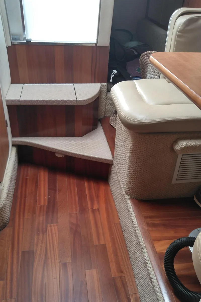 Slide: The Image of Interior of 2006 Sea Ray 280 Sundancer with wooden flooring and beige seating. - 15