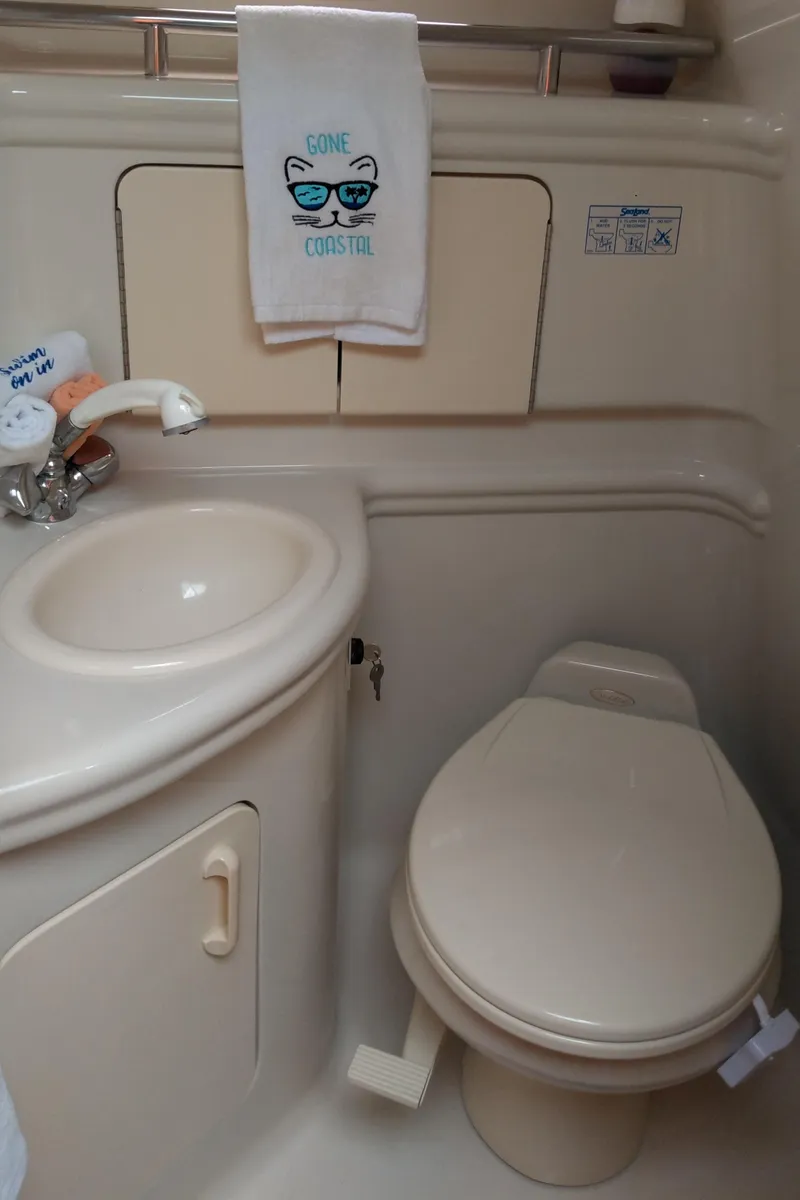 Slide: The Image of 2006 Sea Ray 280 Sundancer bathroom with sink, toilet, and decorative towel. - 20