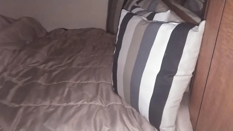 Slide: The Image of Interior cabin of 2006 Sea Ray 280 Sundancer with striped pillow and beige bedding. - 21