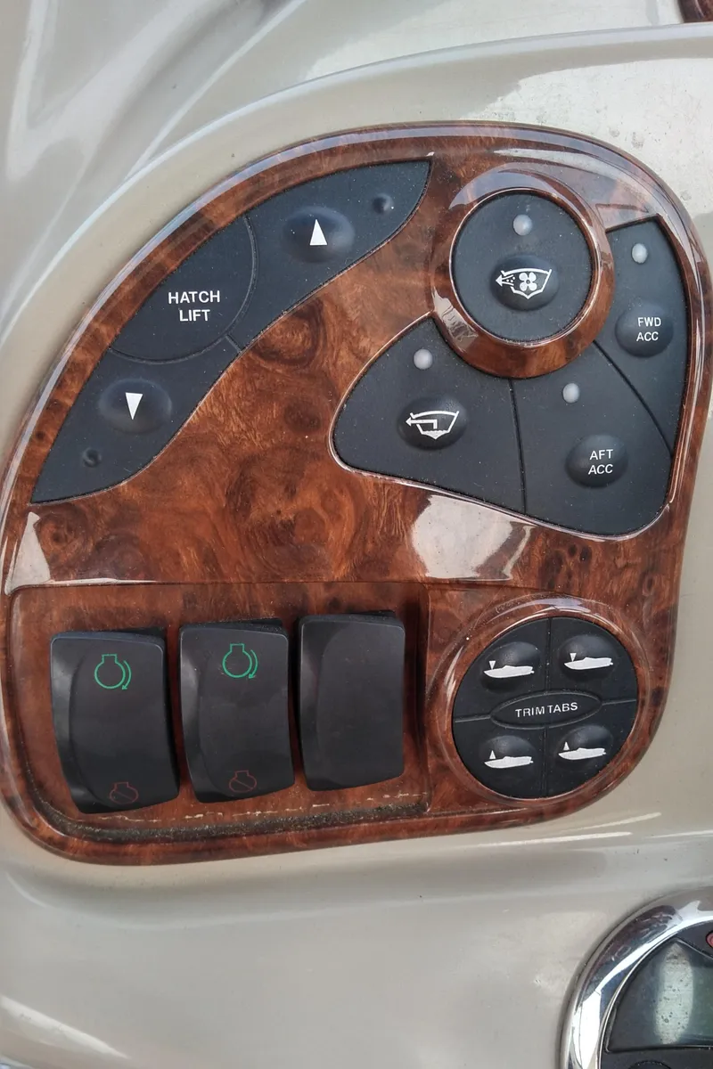 Slide: The Image of Control panel of a 2006 Sea Ray 280 Sundancer boat with wood finish and various switches. - 29