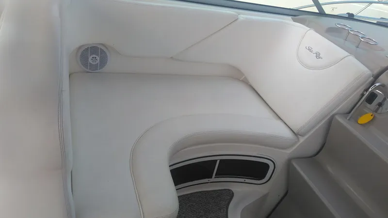 Slide: The Image of 2006 Sea Ray 280 Sundancer interior seating with white upholstery and speaker detail. - 32