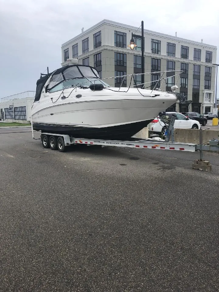 Slide: The Image of 2006 Sea Ray 280 Sundancer boat on trailer, urban background, overcast sky. - 44