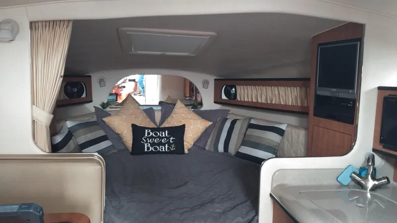 Slide: The Image of Interior of 2006 Sea Ray 280 Sundancer with cozy bed and decorative pillows. - 9