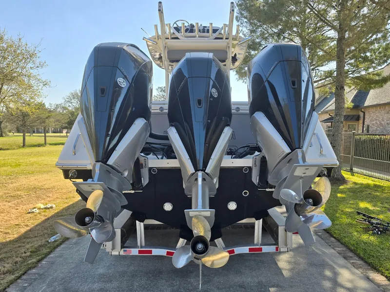 Slide: The Image of Triple outboard motors on a 2015 Everglades 355 Tournament boat, parked outdoors. - 10
