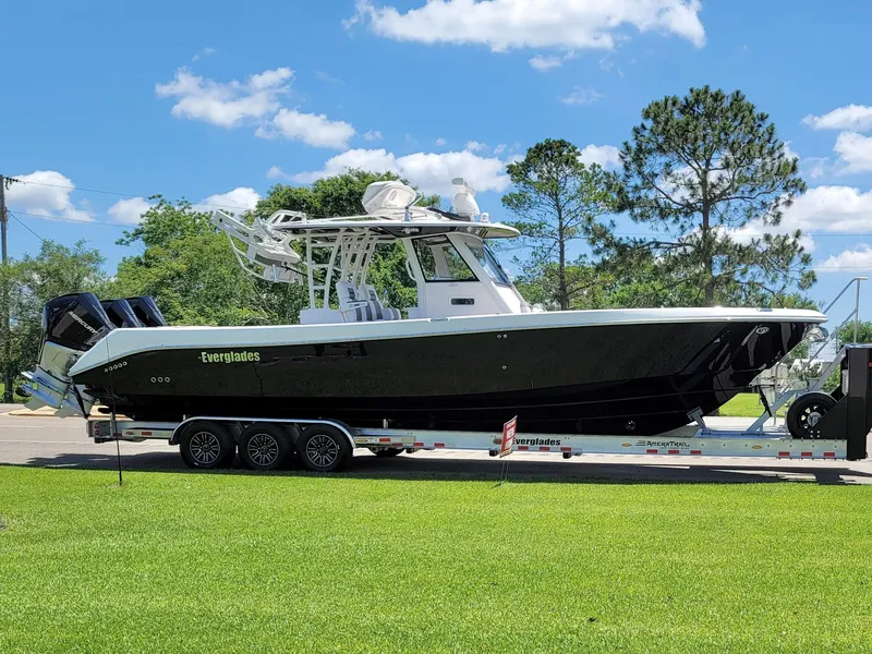 Slide: The Image of 2015 Everglades 355 Tournament boat on trailer, parked on grass, under clear blue sky. - 4