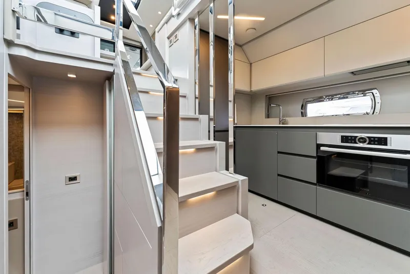 Slide: The Image of Luxurious interior of 2022 Pershing 7X yacht with modern kitchen and sleek staircase design. - 28