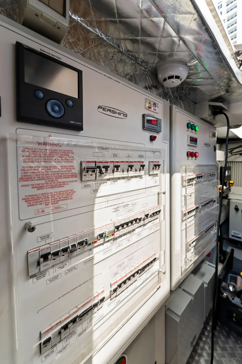 Slide: The Image of Electrical control panel inside a 2022 Pershing 7X yacht, featuring switches and monitoring systems. - 49