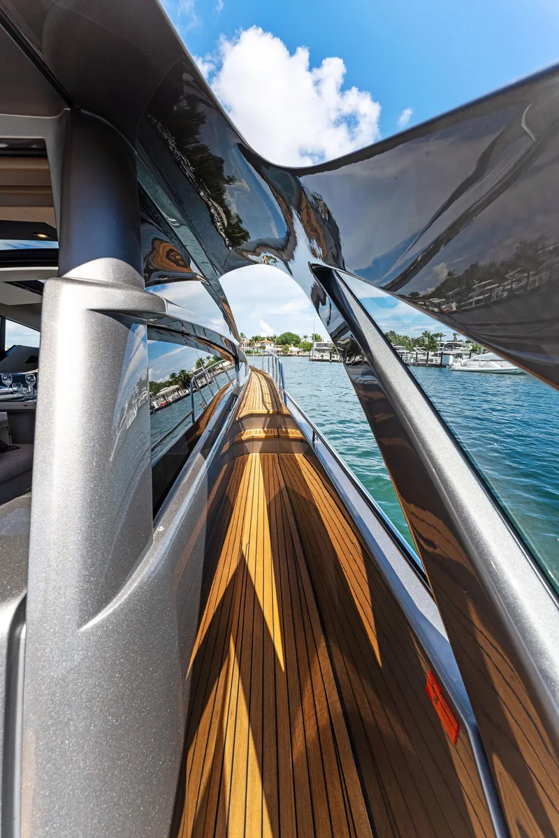 Slide: The Image of 2022 Pershing 7X yacht with sleek design and wooden deck, cruising on a sunny day. - 9