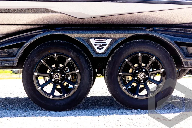 Slide: The Image of 2025 Skeeter FXR 21 Limited trailer wheels on gravel surface. - 22