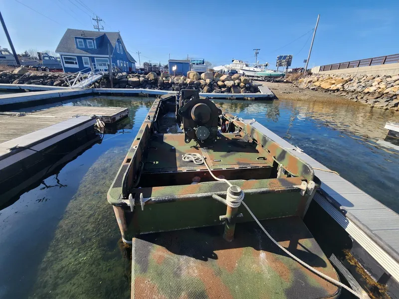 Slide: The Image of SWCC Special Operations Vessel docked, camouflaged, 1999 Recon model, in a marina setting. - 2