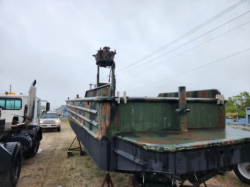 Slide: The Image of 1999 Recon SWCC Special Operations Vessel on land, with trucks in the background. - 9