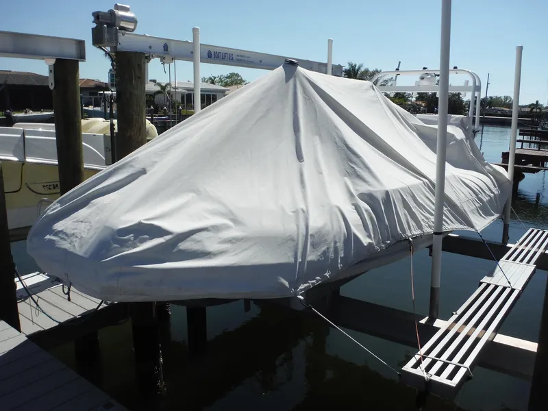 Slide: The Image of Covered 2000 Novurania MX 530 DL boat on a lift by the dock. - 1
