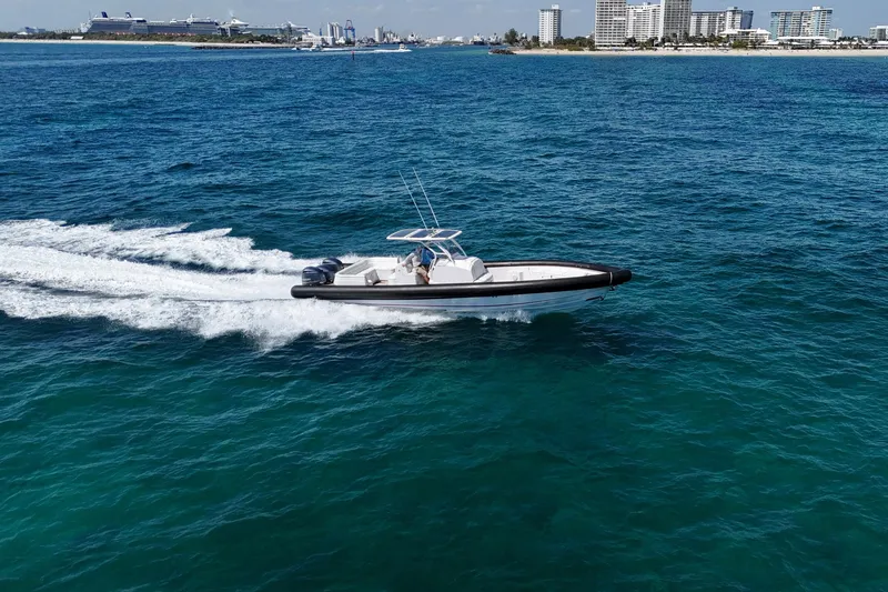 Slide: The Image of 2013 Yellowfin 40 boat cruising on blue ocean near city skyline. - 12