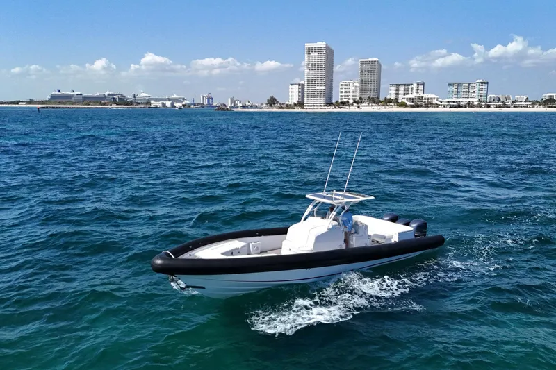 Slide: The Image of 2013 Yellowfin 40 boat cruising on blue ocean near city skyline. - 13