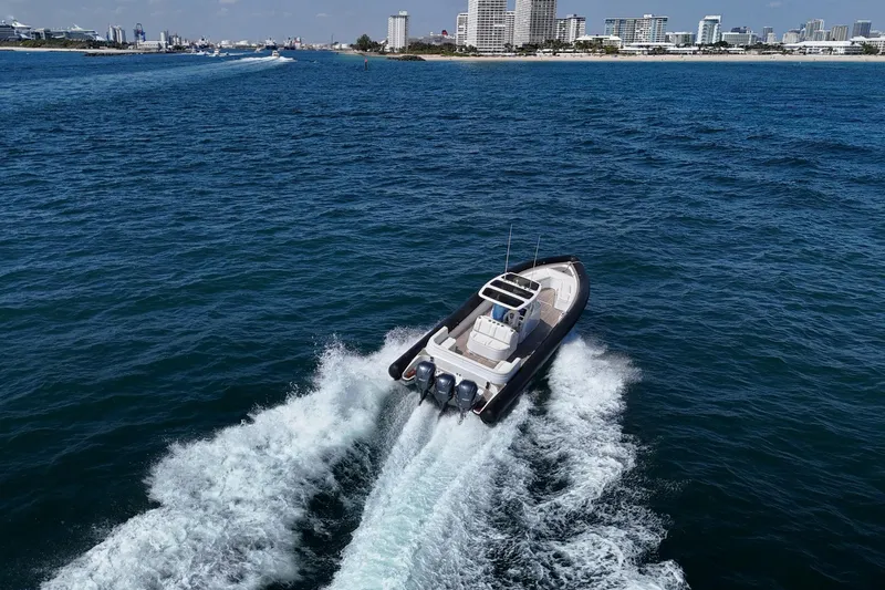 Slide: The Image of 2013 Yellowfin 40 boat cruising on open water near a city skyline. - 17