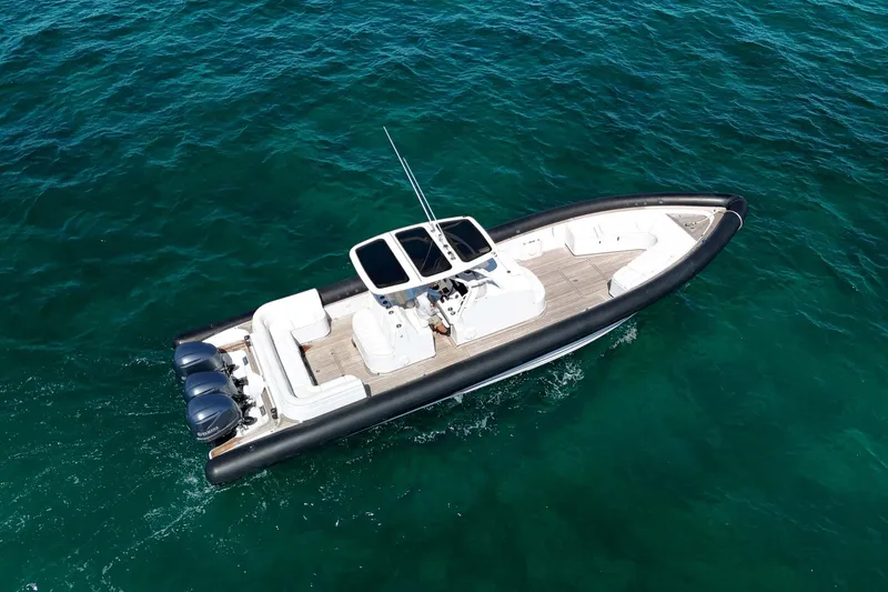 Slide: The Image of 2013 Yellowfin 40 boat cruising on clear blue water, aerial view. - 2