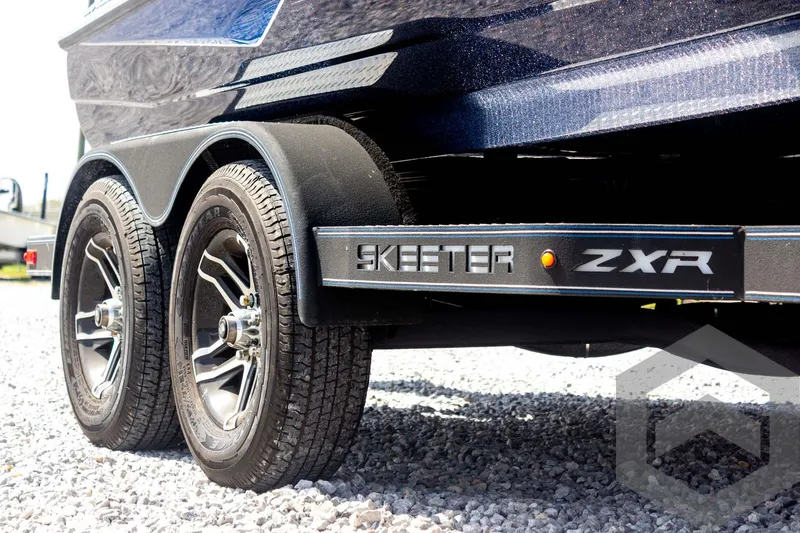 Slide: The Image of 2023 Skeeter ZXR 20 boat trailer with dual wheels on gravel. - 17