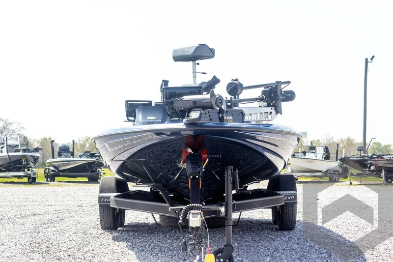 Slide: The Image of 2023 Skeeter ZXR 20 boat on trailer, front view, parked on gravel. - 2