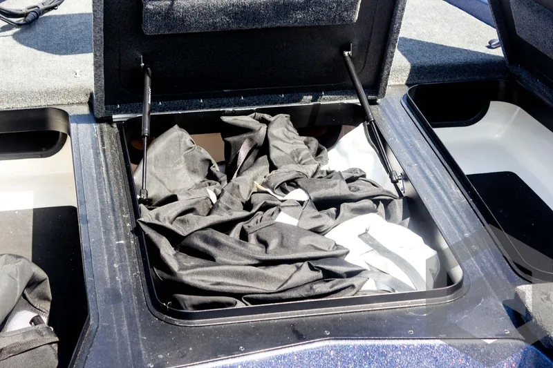 Slide: The Image of 2023 Skeeter ZXR 20 boat storage compartment with black fabric inside. - 23