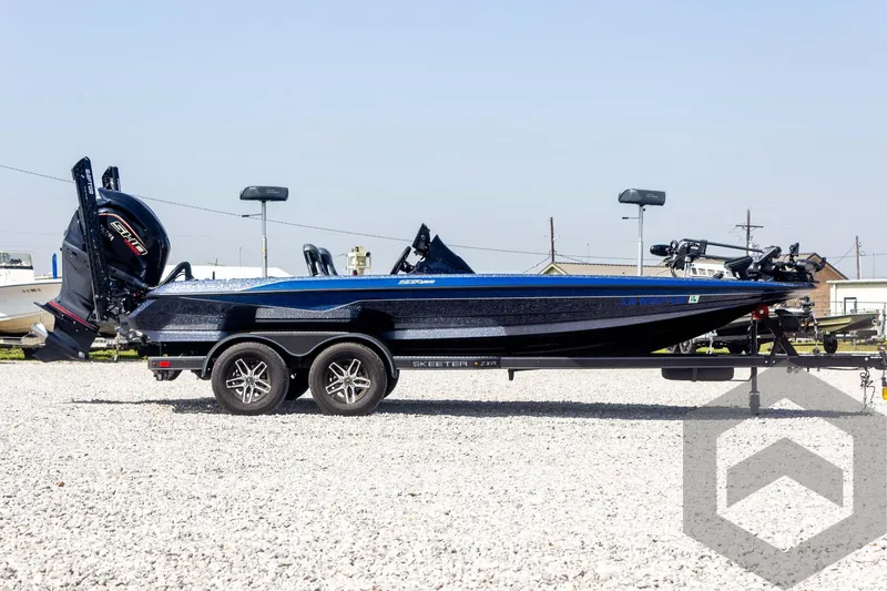 Slide: The Image of 2023 Skeeter ZXR 20 boat, black and blue, on a gravel lot. - 4