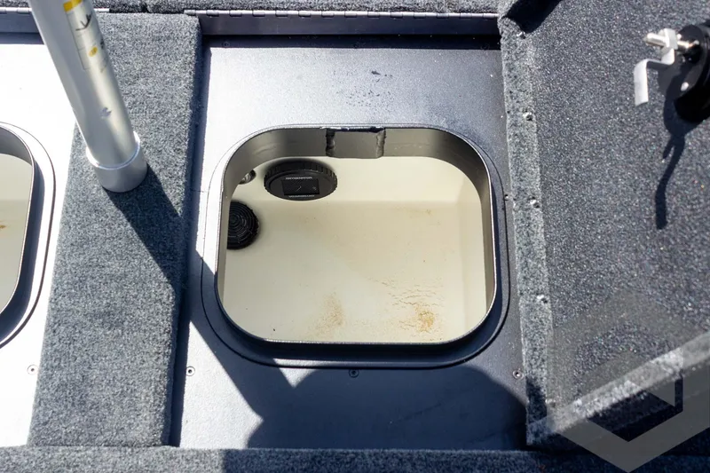 Slide: The Image of 2023 Skeeter ZXR 20 boat storage compartment with open hatch and carpeted deck. - 43