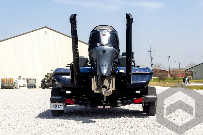Slide: The Image of 2023 Skeeter ZXR 20 boat, rear view, parked on gravel near buildings. - 6