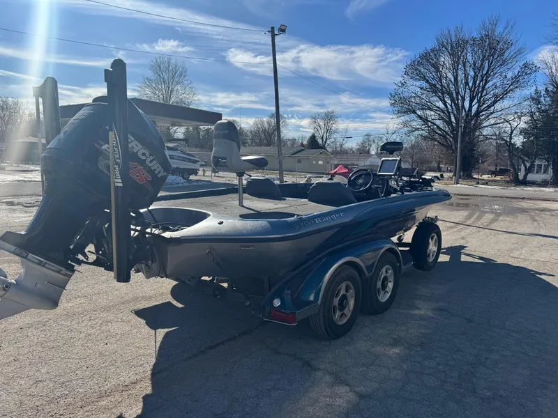 Slide: The Image of 2000 Ranger 520SVX Comanche boat on trailer, parked outdoors under clear blue sky. - 2