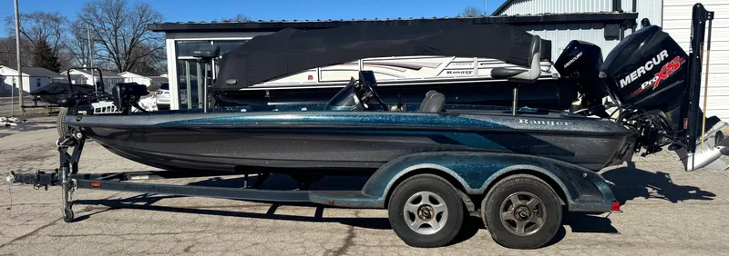 Slide: The Image of 2000 Ranger 520SVX Comanche boat on trailer with Mercury outboard motor, parked outdoors. - 7