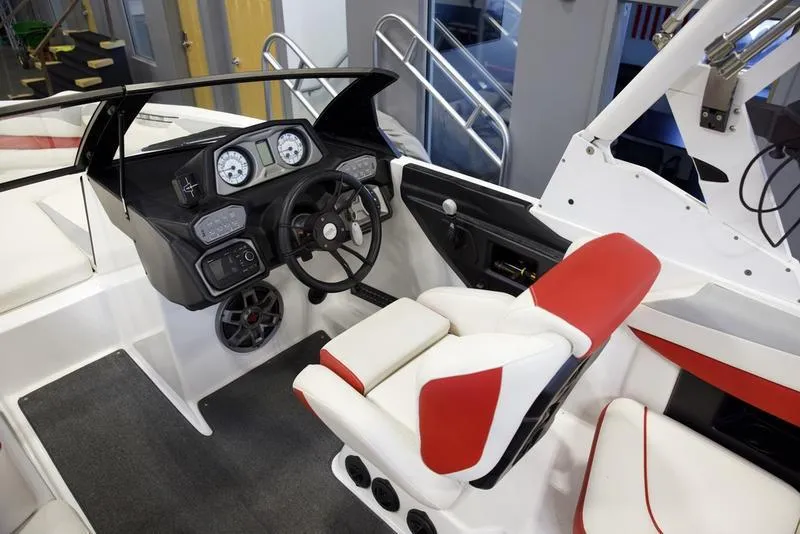 Slide: The Image of 2020 Axis A24 boat interior with red and white seating, steering wheel, and dashboard controls. - 11