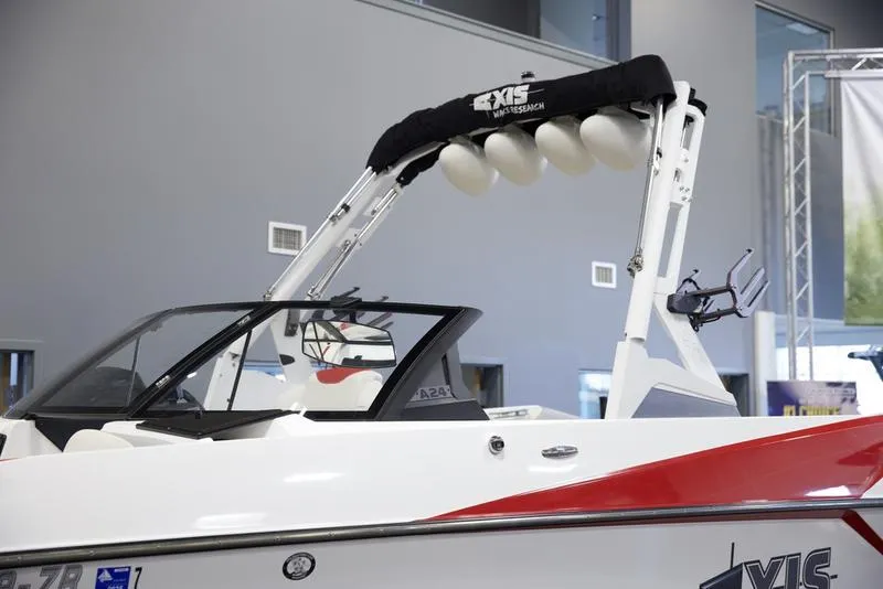 Slide: The Image of 2020 Axis A24 boat with wakeboard tower and red accents in showroom. - 7