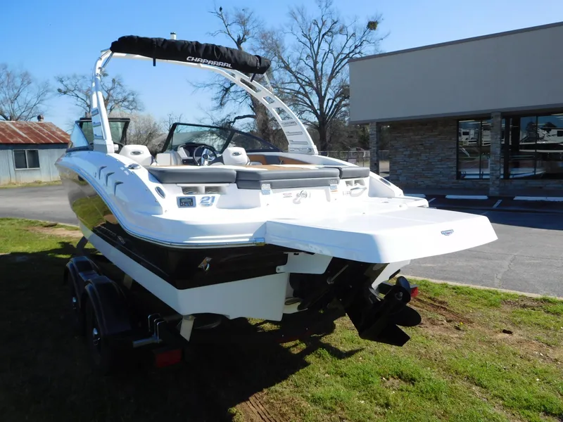 Slide: The Image of 2025 Chaparral 21 SSi boat, white exterior, parked on grass near a building. - 10