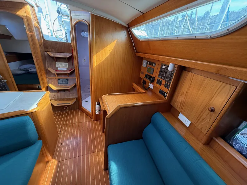 Slide: The Image of Interior of 1999 Jeanneau Sun Odyssey 36.2 sailboat with wood finish and blue seating. - 11