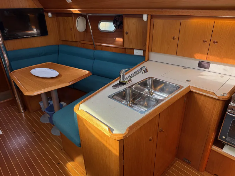 Slide: The Image of Interior of 1999 Jeanneau Sun Odyssey 36.2 yacht with kitchen and seating area. - 13