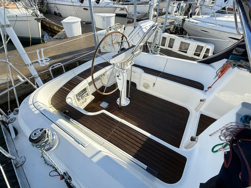Slide: The Image of Cockpit of 1999 Jeanneau Sun Odyssey 36.2 sailboat with wooden flooring and steering wheel. - 2