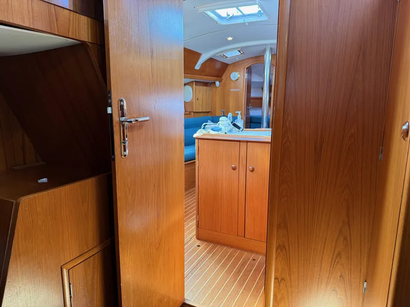 Slide: The Image of Interior of 1999 Jeanneau Sun Odyssey 36.2 sailboat with wooden cabinetry and cozy seating area. - 25