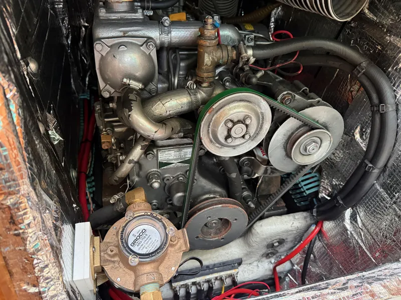 Slide: The Image of Engine compartment of a 1999 Jeanneau Sun Odyssey 36.2 sailboat, showing mechanical components and belts. - 38