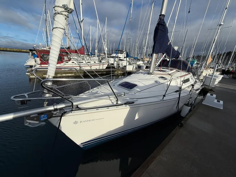 Slide: The Image of 1999 Jeanneau Sun Odyssey 36.2 sailboat docked in a marina, surrounded by other boats. - 5