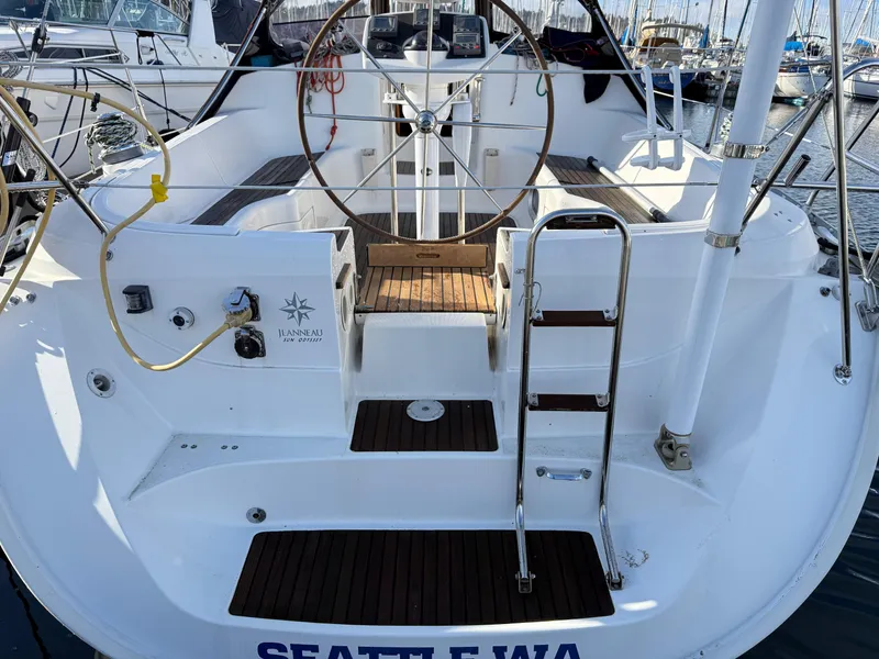 Slide: The Image of 1999 Jeanneau Sun Odyssey 36.2 sailboat cockpit with steering wheel and ladder, docked in Seattle. - 6