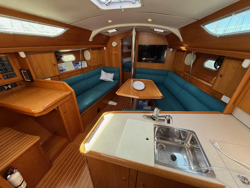 Slide: The Image of Interior of 1999 Jeanneau Sun Odyssey 36.2 yacht with wood finish and blue seating. - 8