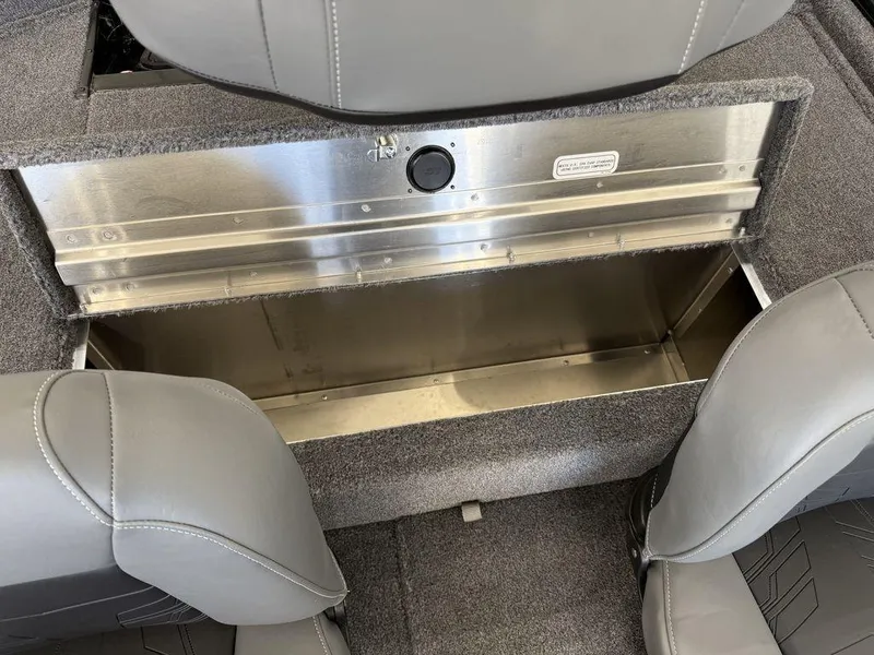Slide: The Image of 2025 Tracker Pro 170 boat storage compartment with gray seating and carpeted interior. - 15