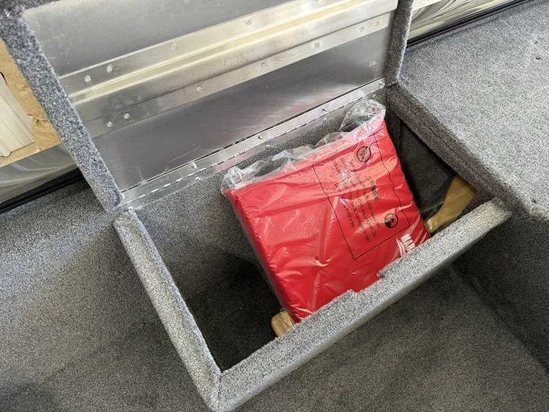 Slide: The Image of Storage compartment in a 2025 Tracker Pro 170 boat with a red life jacket. - 9
