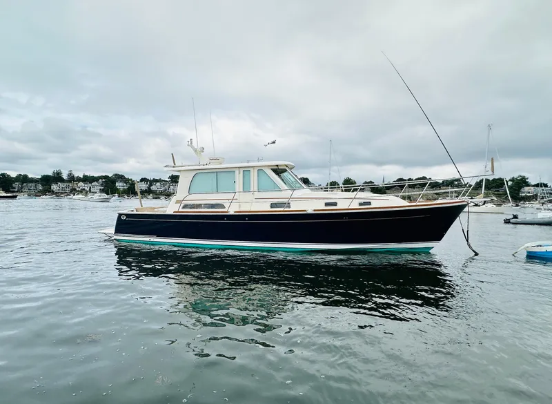 Slide: The Image of 2011 Sabre 40 Sedan boat on calm water, overcast sky background. - 0