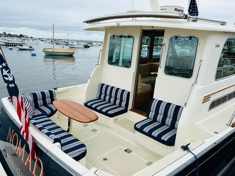 Slide: The Image of 2011 Sabre 40 Sedan yacht with striped seating, docked in a marina. - 10