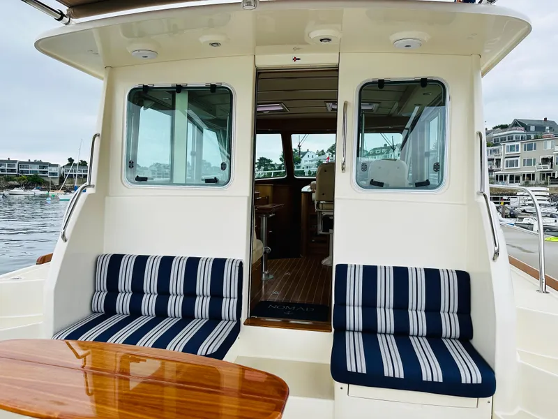 Slide: The Image of 2011 Sabre 40 Sedan yacht with striped seating and wooden table on deck. - 14