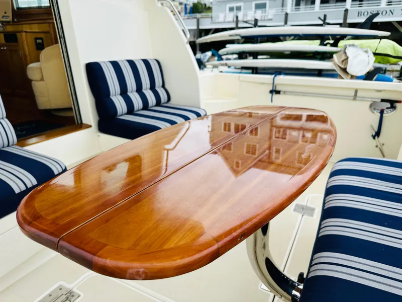 Slide: The Image of 2011 Sabre 40 Sedan yacht interior with polished wooden table and striped seating. - 15