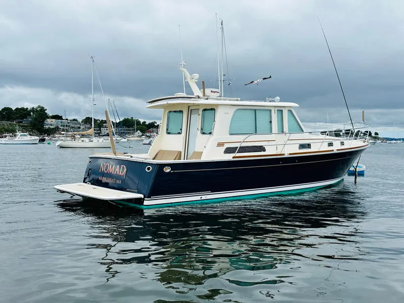 Slide: The Image of 2011 Sabre 40 Sedan boat on calm water, overcast sky. - 2