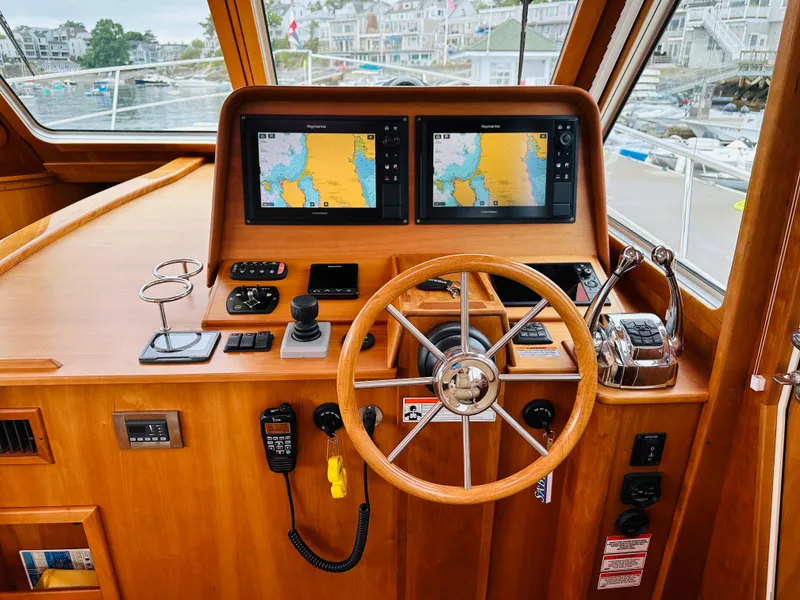 Slide: The Image of 2011 Sabre 40 Sedan helm with dual navigation screens and wooden steering wheel. - 26